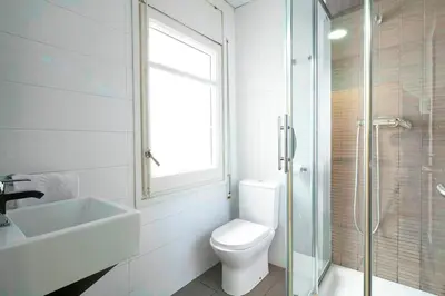 a bathroom with a toilet and a sink and a shower at Putxet by gaiarooms in Barcelona