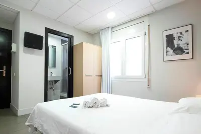 a bedroom with a white bed with a window at Putxet by gaiarooms in Barcelona
