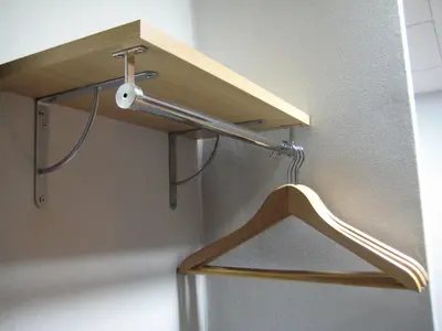 a wooden shelf hanging on a wall with a hanger at Putxet by gaiarooms in Barcelona