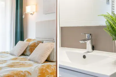 a bathroom with a sink and a bed with pillows at Sant Sebastià Moderno apartamento a 100 metros de la playa in Sitges