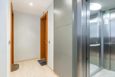 a hallway with white cabinets and a glass door at Sant Sebastià Moderno apartamento a 100 metros de la playa in Sitges