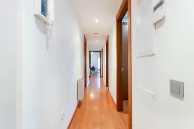 a hallway of a house with white walls and wooden floors at Sant Sebastià Moderno apartamento a 100 metros de la playa in Sitges