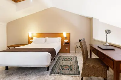 a hotel room with a bed and a desk at PARK SEDO Aparthotel in Rubí