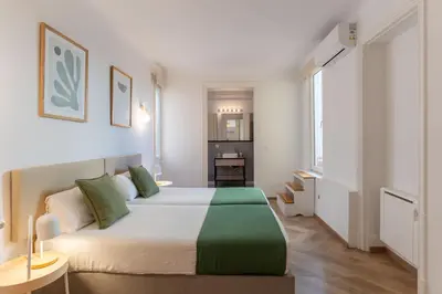 a bedroom with a large white bed with green pillows at SibsBcn-Paseo de Gracia Penthouse-Luxury-Terraces in Barcelona