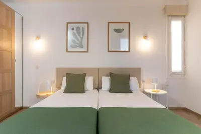 a bedroom with a large white bed with green pillows at SibsBcn-Paseo de Gracia Penthouse-Luxury-Terraces in Barcelona
