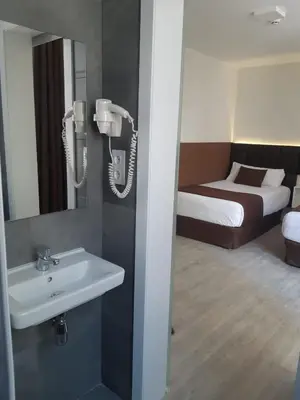 a bathroom with a sink and a phone on the wall at BCN Urbaness Hotels Bonavista in Barcelona