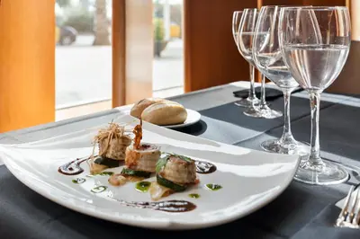 a plate of food on a table with wine glasses at Hotel Best Front Maritim in Barcelona