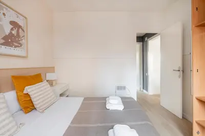 a bedroom with a white bed with orange pillows at Apartments Sata Sagrada Familia Area in Barcelona