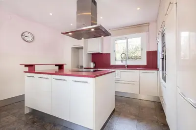 a kitchen with white cabinets and a red counter top at Apartments Sata Sagrada Familia Area in Barcelona