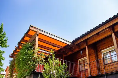 a wooden house with a balcony and trees at Hotel Somlom - ECO Friendly Montseny in Sant Esteve de Palautordera