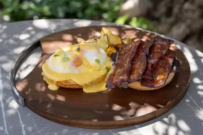 a breakfast sandwich with bacon and eggs on a plate at Catalonia Ramblas 4* Sup in Barcelona