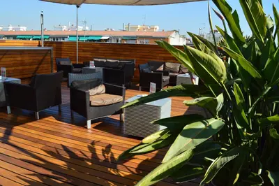 a rooftop patio with couches and tables on a building at Hotel Soho in Barcelona