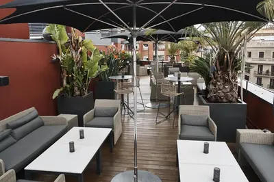 a restaurant with tables and chairs and an umbrella at Hotel Villa Emilia in Barcelona