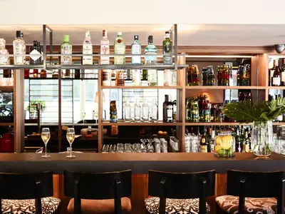 a bar with wine glasses and bottles on shelves at Hotel Villa Emilia in Barcelona
