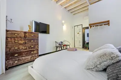 a bedroom with a large bed and a dresser at Hauzify I Novavila Centre Rooms in Vilanova i la Geltrú