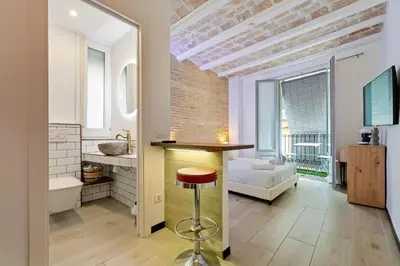 a bathroom with a sink and a stool in a room at Hauzify I Novavila Centre Rooms in Vilanova i la Geltrú