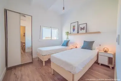 a bedroom with two beds and a mirror at Welcomy Poblenou in Barcelona