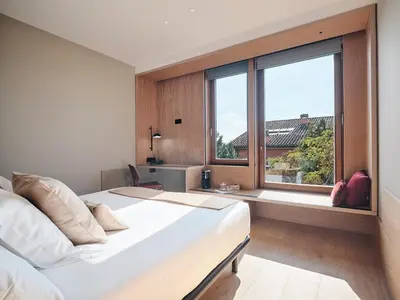 a bedroom with a bed and a large window at Qgat Restaurant Events & Hotel in Sant Cugat del Vallès