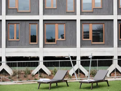 two chairs sitting in front of a building at Qgat Restaurant Events & Hotel in Sant Cugat del Vallès