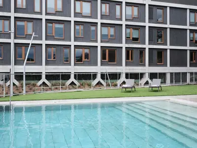 a hotel with a swimming pool in front of a building at Qgat Restaurant Events & Hotel in Sant Cugat del Vallès