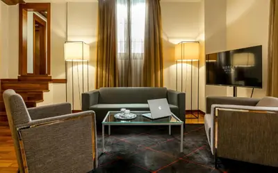 a living room with a couch and a laptop on a table at Mercer House Bòria BCN in Barcelona