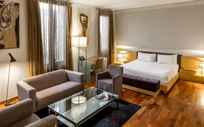 a hotel room with a bed and a couch at Mercer House Bòria BCN in Barcelona