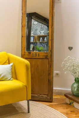 a yellow couch in a living room with a wooden door at Eco Boutique Hostal Grau in Barcelona
