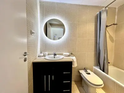 a bathroom with a sink and a toilet and a mirror at Acogedor apartamento entero in Terrassa
