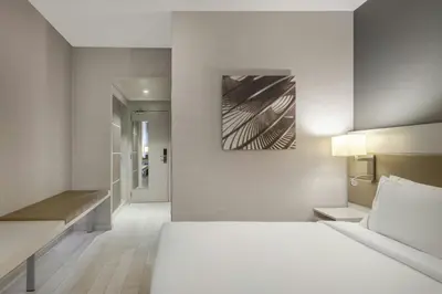 a bedroom with a white bed and a painting on the wall at AC Hotel San Cugat by Marriott in Sant Cugat del Vallès