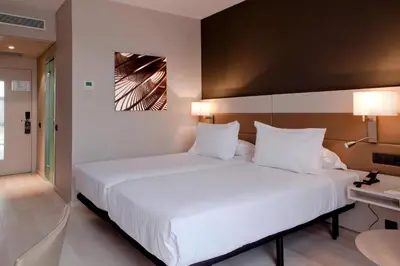 a bedroom with a large white bed with white pillows at AC Hotel San Cugat by Marriott in Sant Cugat del Vallès