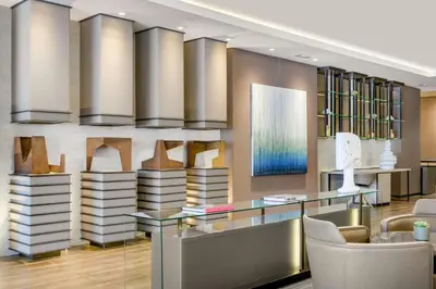 a lobby with a desk and chairs and books at AC Hotel San Cugat by Marriott in Sant Cugat del Vallès