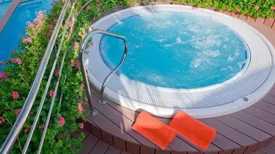 an overhead view of a swimming pool with orange chairs at KAKTUS Hotel Kaktus Playa in Calella