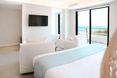 a bedroom with a bed and a view of the ocean at KAKTUS Hotel Kaktus Playa in Calella