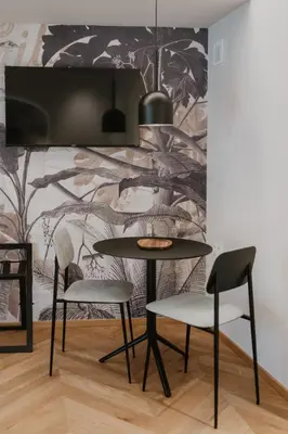 a table and chairs in a room with a wall mural at Hotel Petit Luxe in Terrassa