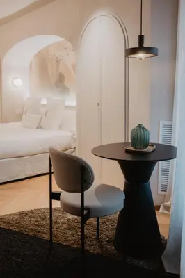 a table and a chair in a room with a bed at Hotel Petit Luxe in Terrassa