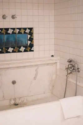 a white bath tub with a shower in a bathroom at Fonda Hotel 1771 in Granollers