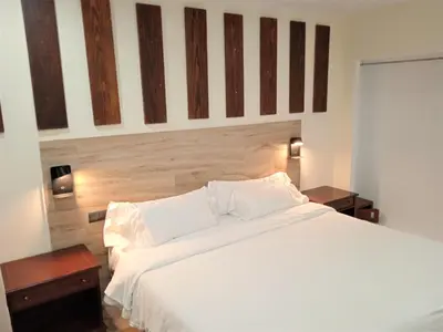 a bedroom with a large white bed and two tables at Hotel 153 in Castelldefels