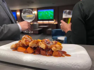 a plate of food on a table with a glass of wine at BAH Barcelona Airport Hotel in El Prat de Llobregat