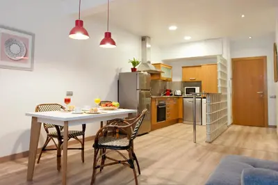 a kitchen and dining room with a table and chairs at MH Apartments S. Familia in Barcelona