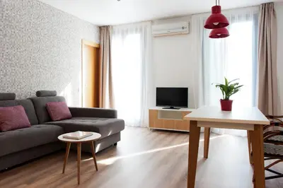 a living room with a couch and a tv at MH Apartments S. Familia in Barcelona