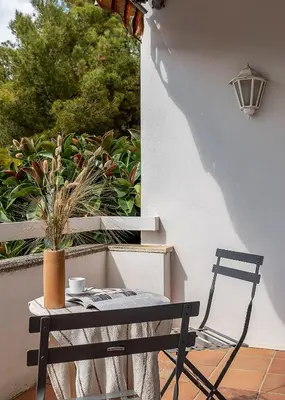 a black chair and a table on a patio at Canela Homes COSTA CASA AILA in Castelldefels