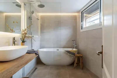 a bathroom with a large white tub and a sink at Canela Homes COSTA CASA AILA in Castelldefels