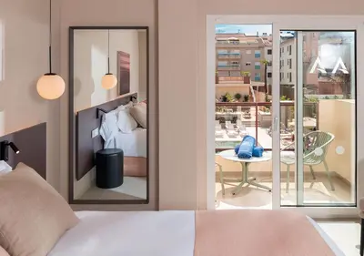 a bedroom with a bed and a view of a balcony at AQUA Hotel Promenade & Spa 4Sup in Pineda de Mar