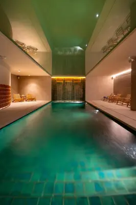 a swimming pool with blue water in a building at AQUA Hotel Promenade & Spa 4Sup in Pineda de Mar