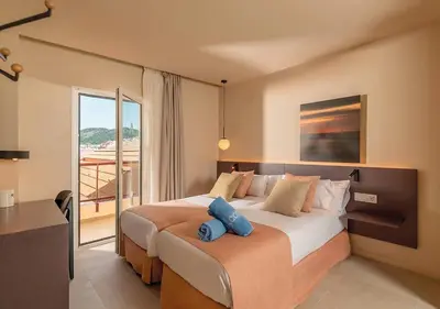 a bedroom with a large bed and a balcony at AQUA Hotel Promenade & Spa 4Sup in Pineda de Mar