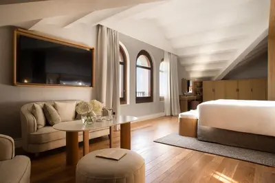a bedroom with a bed and a table and a couch at METT Barcelona GL - A Leading Hotel of the World in Barcelona