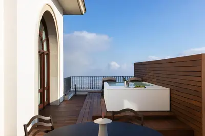 a balcony with a white table and a view of the ocean at METT Barcelona GL - A Leading Hotel of the World in Barcelona