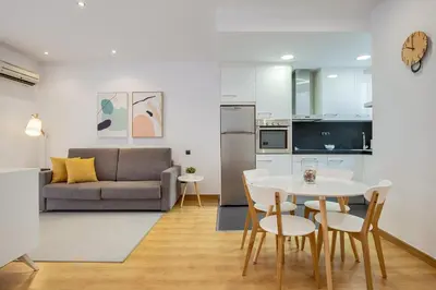 a kitchen and living room with a table and chairs at Feelathome Center Apartments in Barcelona