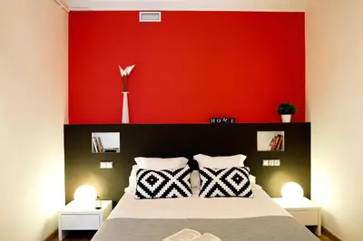 a bedroom with a red wall and a bed at Feelathome Center Apartments in Barcelona