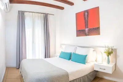a bedroom with a large white bed with blue pillows at Feelathome Center Apartments in Barcelona